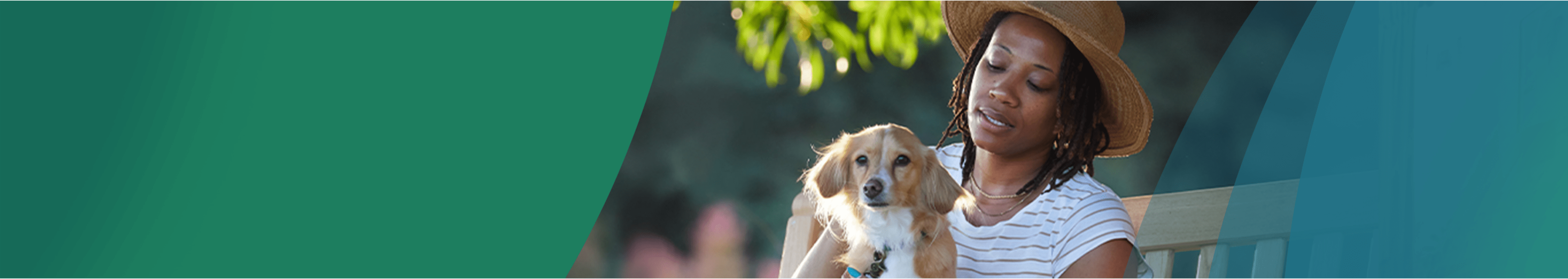 A Black woman in her 40s is sitting on a park bench outside, petting her small tan dog on her lap. The woman has chin-length black curls and is wearing a sun hat. Actor portrayal.