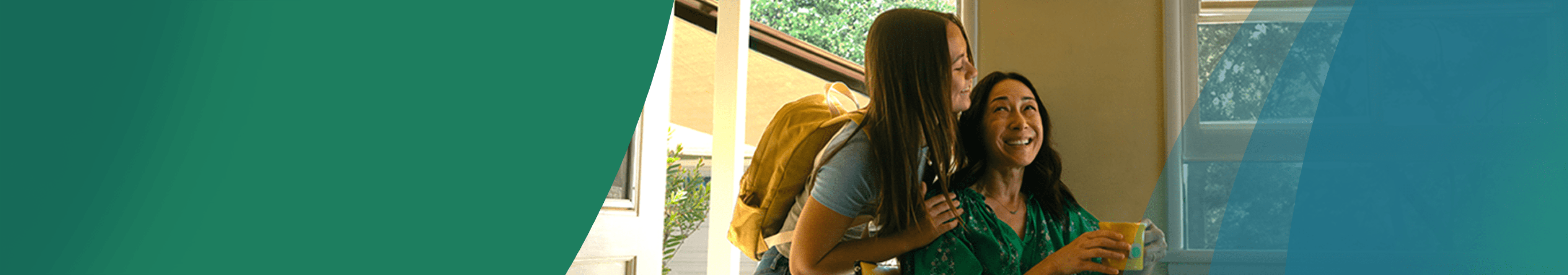 An Asian woman in her 50s is sitting at the kitchen table with a cup of tea and a slice of toast. Her teenage daughter is giving her a quick hug from behind as she is about to leave for school. They are looking at each other and smiling. Actor portrayals.