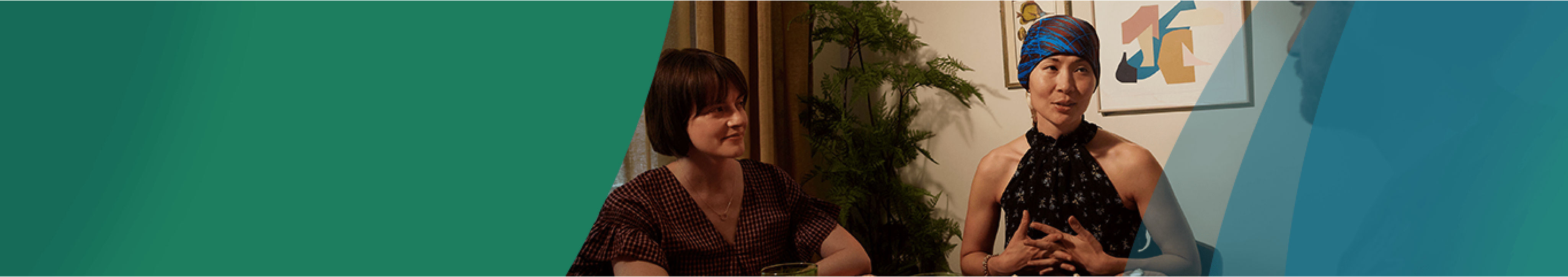 An Asian woman in a headscarf sitting on a chair speaking to a man while sitting next to a white woman with shoulder-length brown hair. Actor portrayals.