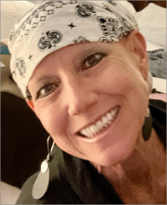 Karen, a woman receiving TRODELVY, is smiling at the camera. Karen is a White woman wearing a white bandana, and a green shirt.