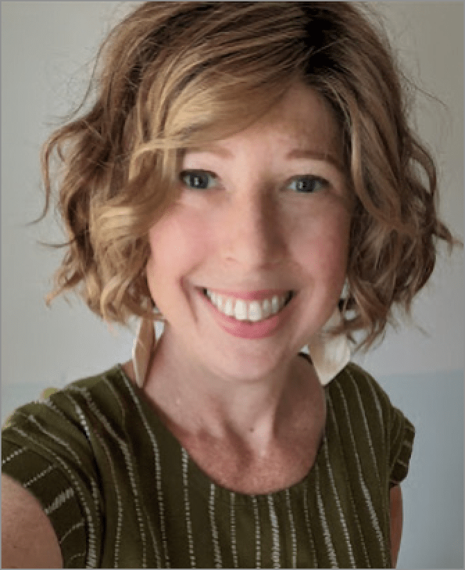 Katherine, a woman receiving TRODELVY, is smiling at the camera. Katherine is a White woman wearing a blonde wig, and a brown shirt with vertical white stripes.
